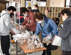 坂井芋を販売する児童（左）と購入する地域住民