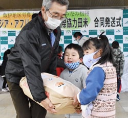 JA職員とともにトラックへお米を積み込む園児