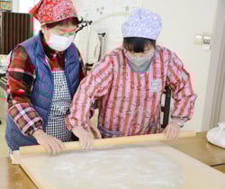 教えあいながらそば打ちを行う部員