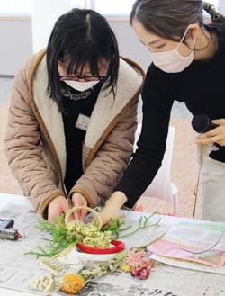 講師の稲垣さん（左）に教わりながらしめ縄を作る学生