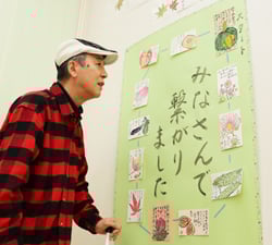 メッセージを添えた絵手紙を眺める来店客