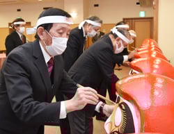 ダルマに目を入れる小山果実専門委員長