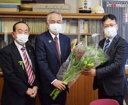 飯島小学校での花束贈呈の様子(左から成澤支所長、下島理事、牧内校長)
