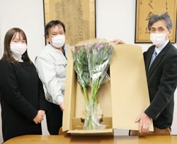 大久保校長（右）に花を渡すJA職員