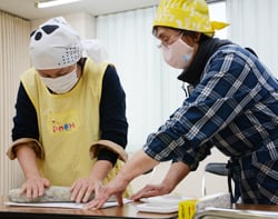 やしょうまをつくる職員（左）と指導する女性部員（右）