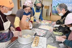形成したまんじゅうを蒸し器にいれる参加者