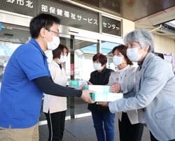 「デイサービスけいすい」の職員に介護用手袋を寄贈する女性部員