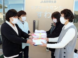 ケアネットセンターすわこの職員に清拭布を手渡す矢﨑正子ブロック長（右から2番目）と岩波正枝副ブロック長（右）
