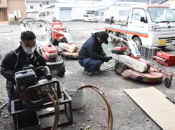 農業機械センター職員2人が点検・修理作業を進める