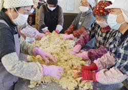 つぶした大豆と麹などを混ぜ合わせる参加者