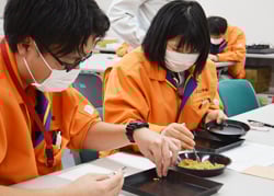 種籾を1粒ずつ調査する指導員