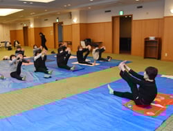 講師に習ってポーズに挑戦する参加者