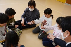 子供たちとお手玉使って遊ぶ百瀬支部長