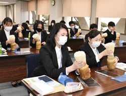 エノキタケのもぎ取りをする採用内定者