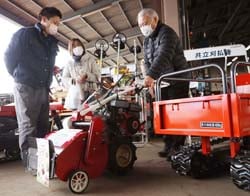 JA職員（左）に教わりながら、草刈機の動作を確かめる来場者