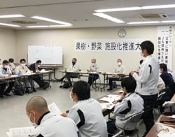 果樹施設化の推進報告をする営農技術員（右）と真剣に聞く参加者