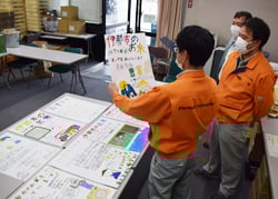 児童が作成したポスターを見るJA職員