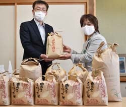 食品を受け取る千國課長（右）と寄贈する鶴見部長（左）