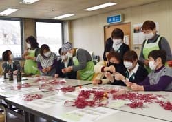 シトラスリボンを作る女性部員とJA職員ら