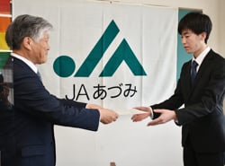 新採用職員（右）に辞令交付する千國組合長（左）