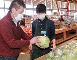 直売所で出荷野菜の取り扱いを学ぶ岩下さん（右）