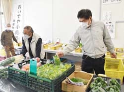 購入する農産物を手に取る来店客
