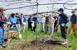 植え付けの実演をする飯塚さんと学ぶ参加者ら