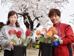 市村園長（左）にダリアを手渡すりんごの里の宮澤さん
