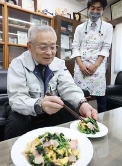 栄養たっぷりの「ふんわり卵炒め」を試食する小松組合長（左）