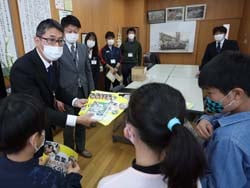 「農業とわたしたちのくらし」を子どもたちに手渡す河西所長ら