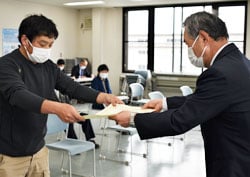 総会で榑沼会長（右）から表彰される塩原さん（左）