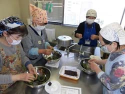 生地にあんこを包んで草餅を作る参加者ら