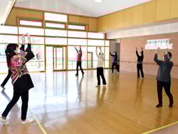 センター職員より踊りを教わる地域住民ら