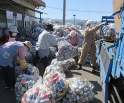 集まったアルミ缶を業者のトラックに積込む女性部員
