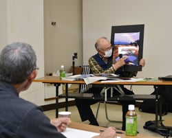 撮影した写真の撮影ポイントを説明する林さん