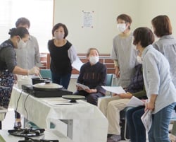 調理器具を使った料理の出来栄えを確認する女性部員