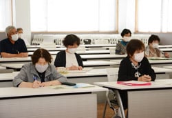 真剣な表情で田中学長の話を聞く学生