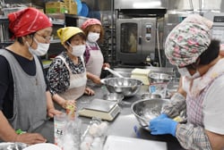 作業工程を確認しながらパン作りを進める協力員