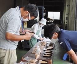 ちくまライスセンターで等級付けを行う営農技術員