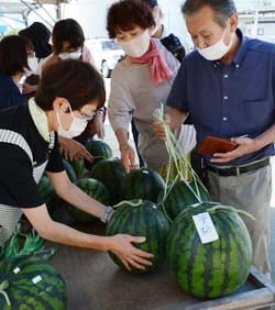 対面販売を楽しみつつスイカを買い求める来場者