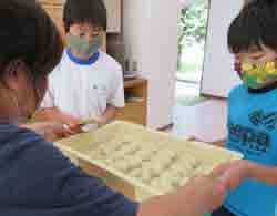 レタス蒸しケーキを受け取る洗馬小学校5年生の児童