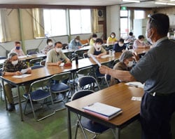 秋野菜の播種時期を説明する守谷さん（手前）と耳を傾ける参加者