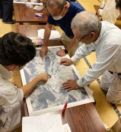 地図上に各自の農地の色分けを行う生産者ら