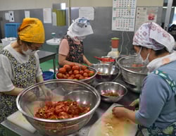 ケチャップ材料のトマトを準備する女性部員