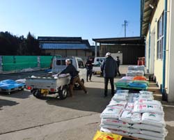 農家のトラックに肥料を積み込む職員