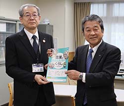 熊谷教育長（左）に教材本を贈呈した寺沢組合長（右）