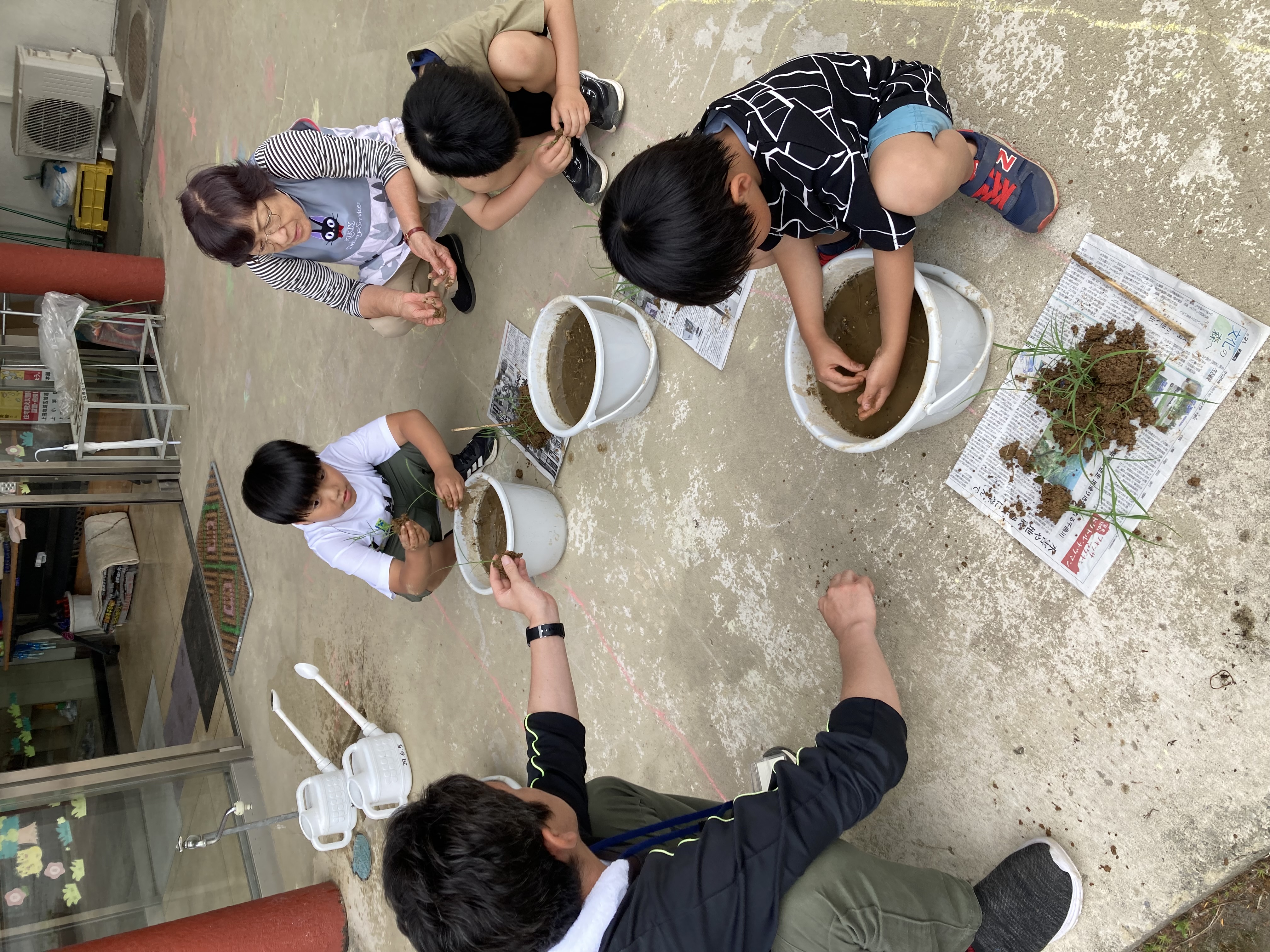 営農技術員の指導で田植えをする子どもたち