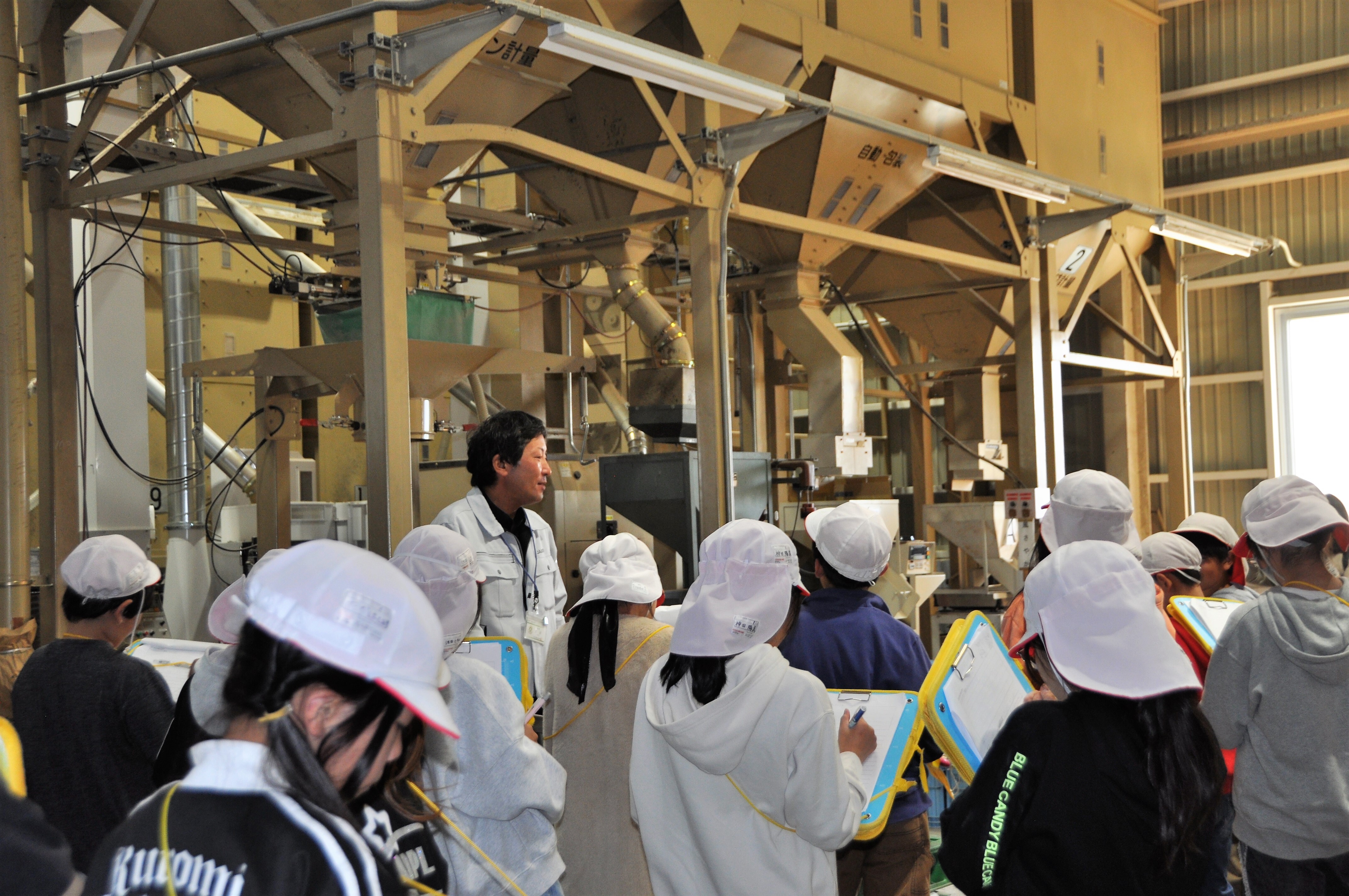 営農技術員の説明をメモを取りながら聞く児童