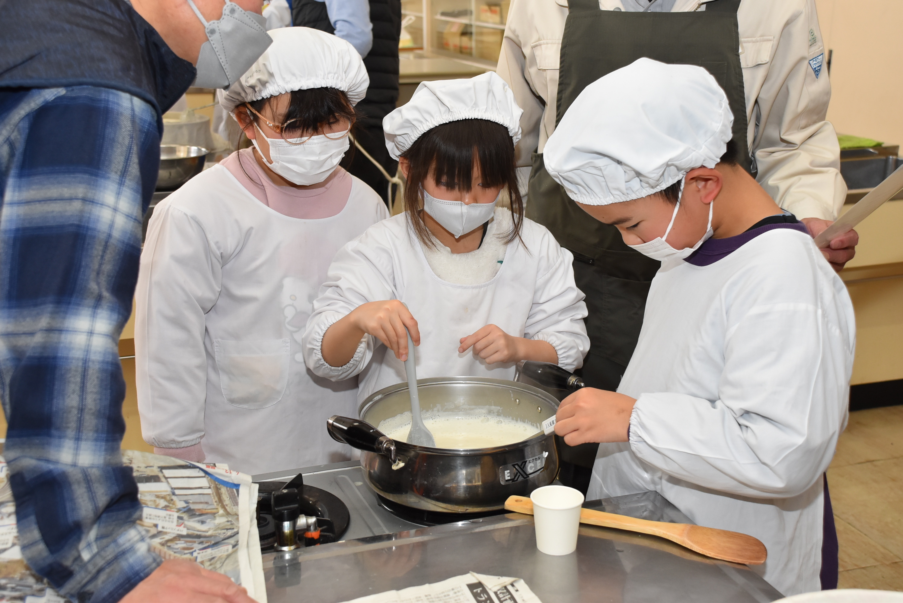 温度を測りながらかくはんする児童