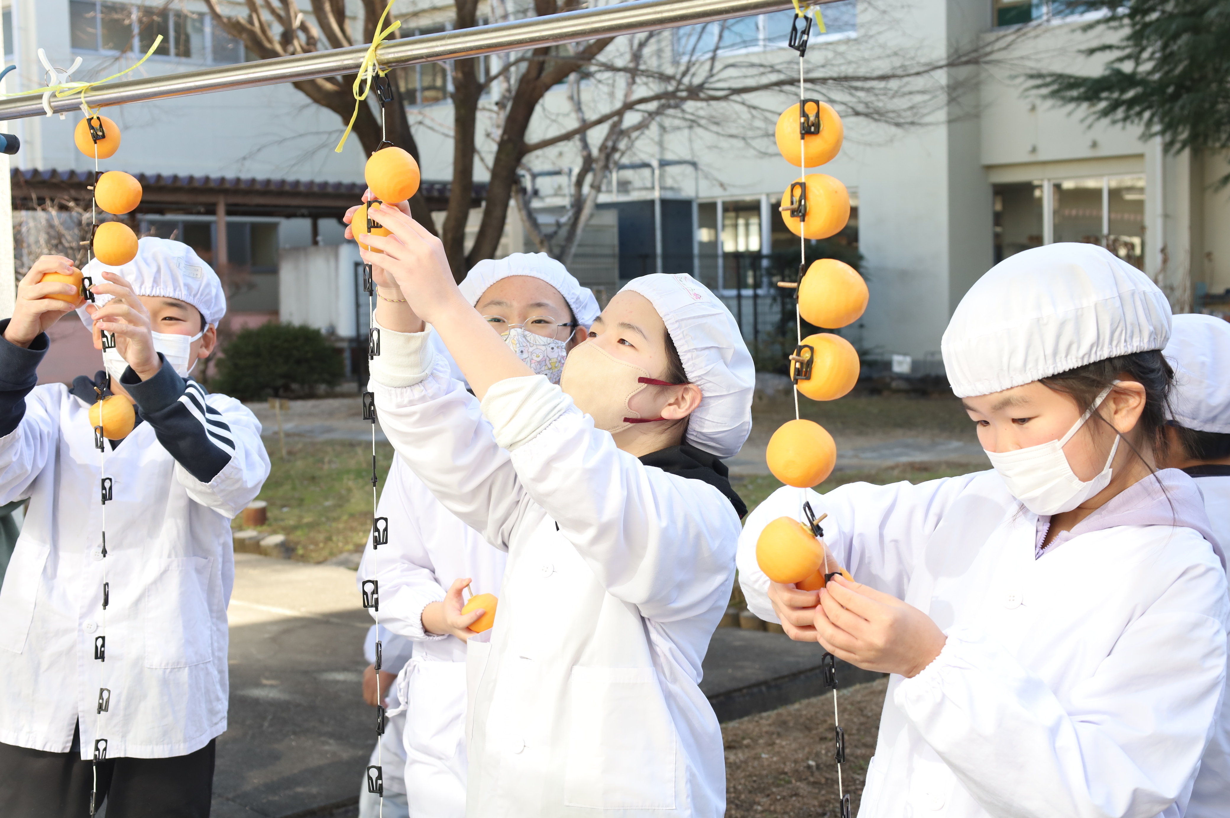 真剣な表情でつるし作業をする児童ら